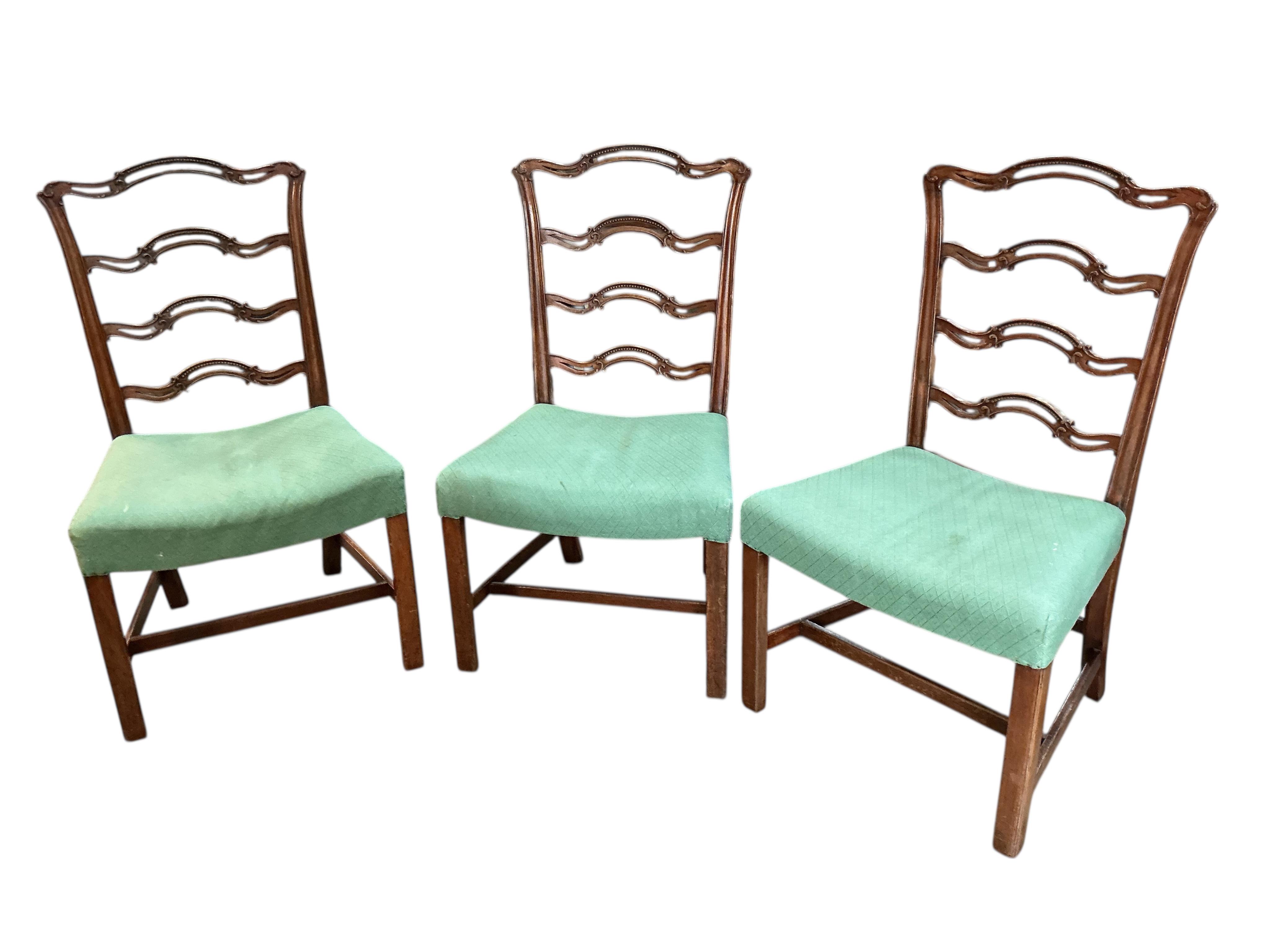 A set of nine George III mahogany pierced ladderback dining chairs, two with arms